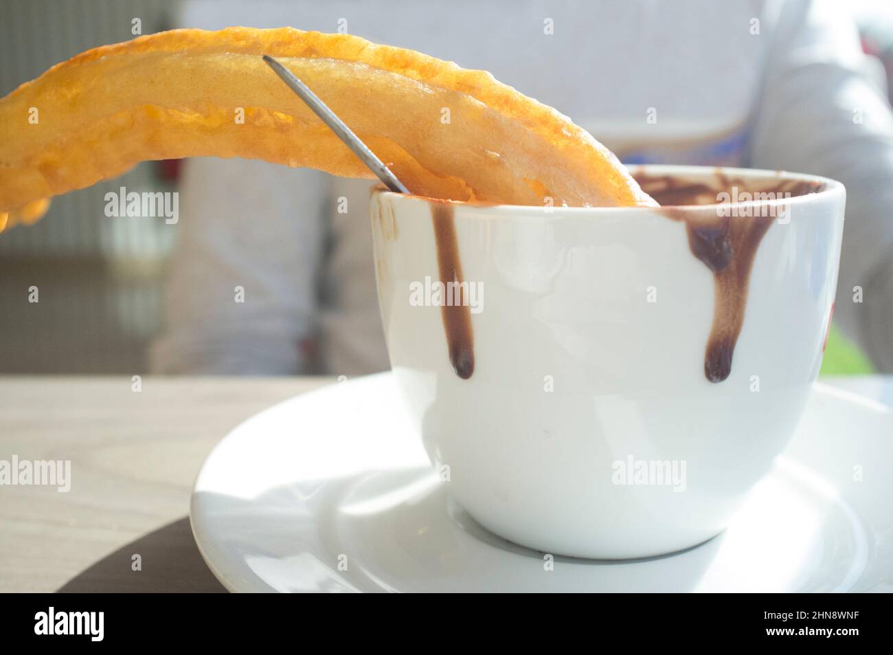 Immersione del churro spagnolo in una tazza di cioccolato caldo. Messa a fuoco selettiva Foto Stock
