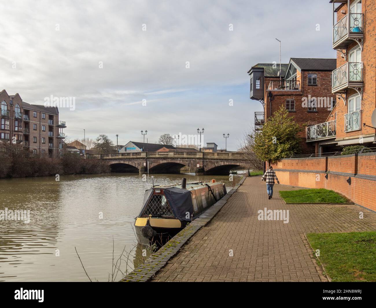 Vista generale del fiume Nene a Southbridge Northampton Regno Unito in una soleggiata giornata invernale; ormeggiata narrowboat e donna esercizio fisico. Foto Stock