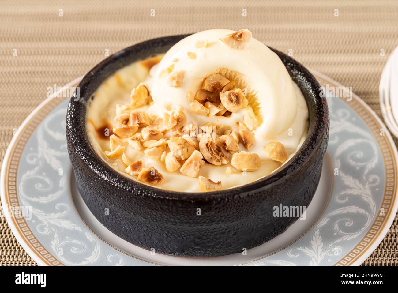 Sutlac Turco o Pudding di riso al forno con nocciole in ciotola di argilla. Foto Stock