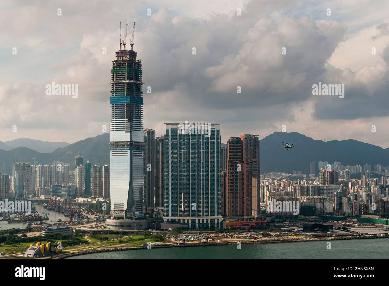 L'elicottero Macau Sky Shuttle vola di fronte all'ICC in costruzione, West Kowloon, Hong Kong, 2008 Foto Stock