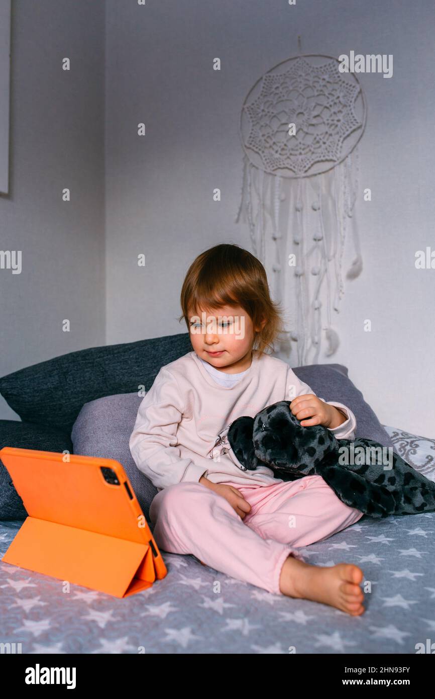 Bambina che guarda i video su Apple iPad tablet a casa. Computer