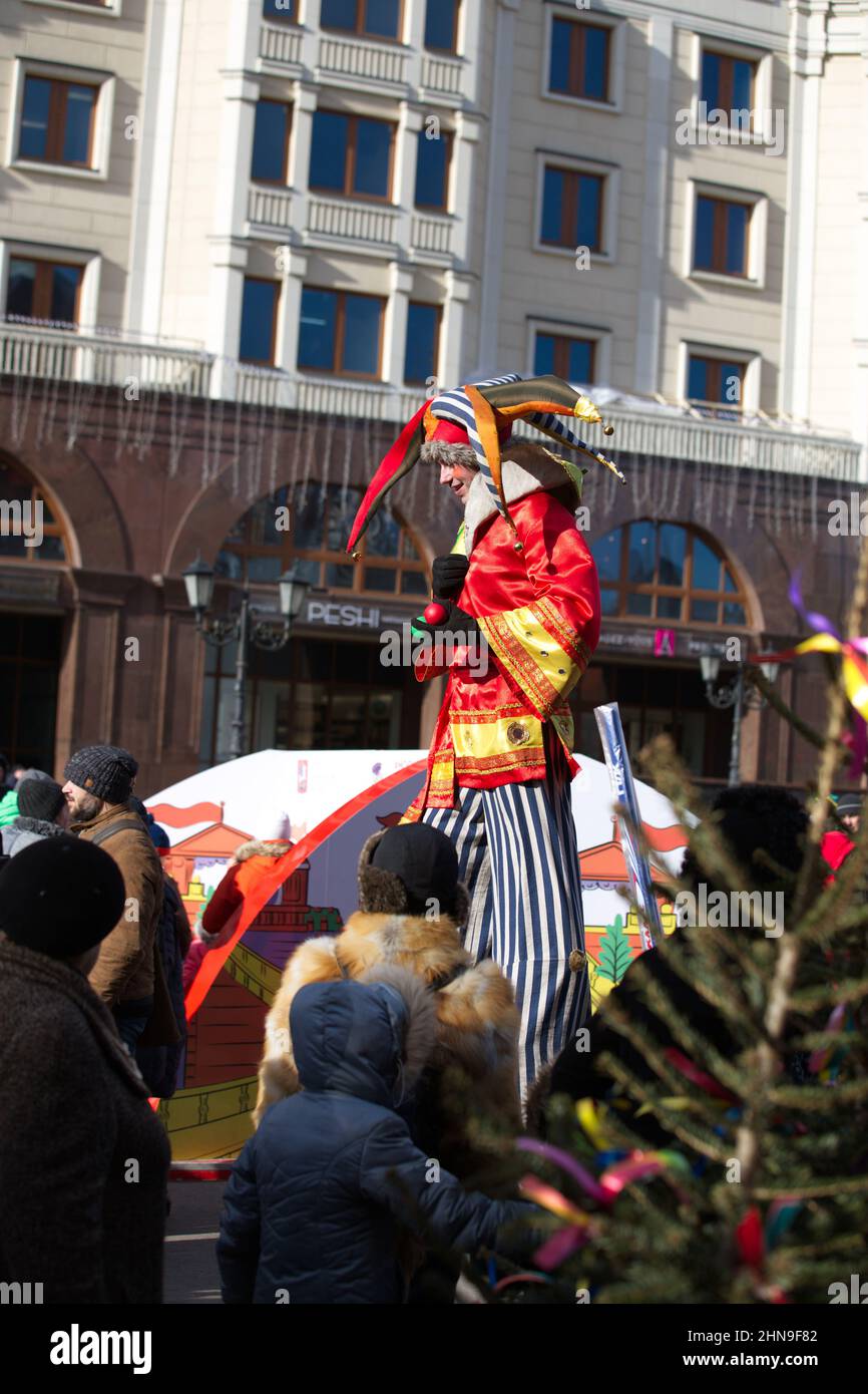 Il clown alto è prezzemolo su palafitte. Carnevale in onore di Maslenitsa. Foto Stock