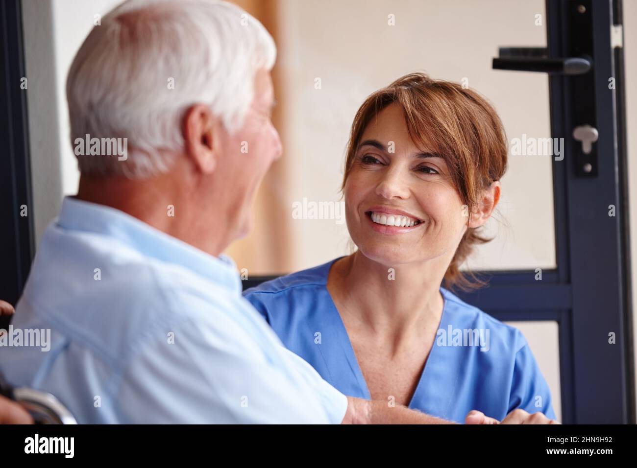 Aiutare gli altri è la sua chiamata. Scatto ritagliato di un'infermiera femminile che controlla il paziente anziano. Foto Stock