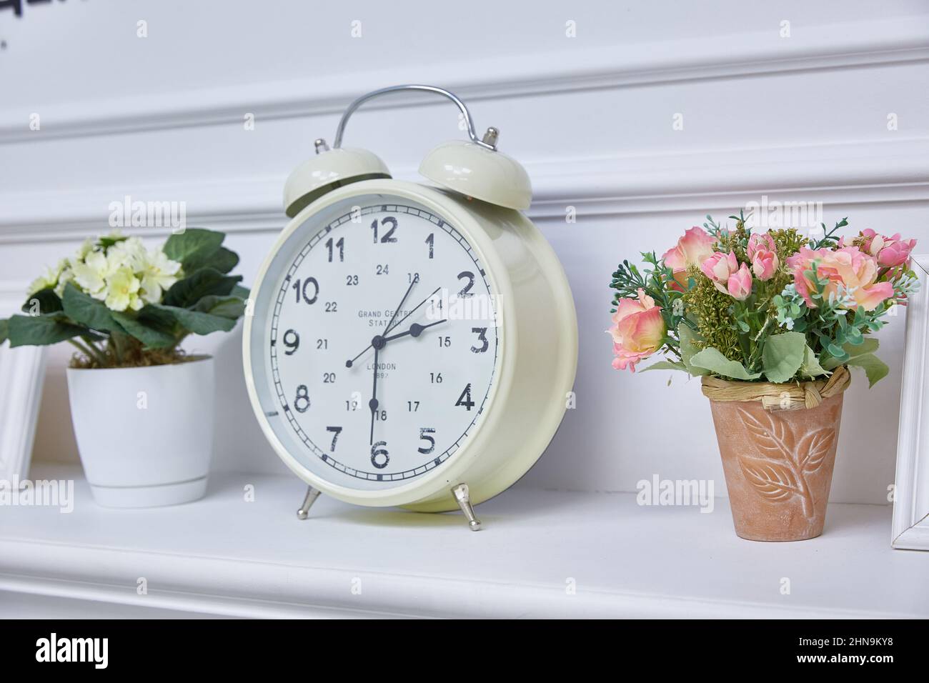 ripiano con orologi e vasi con fiori Foto Stock