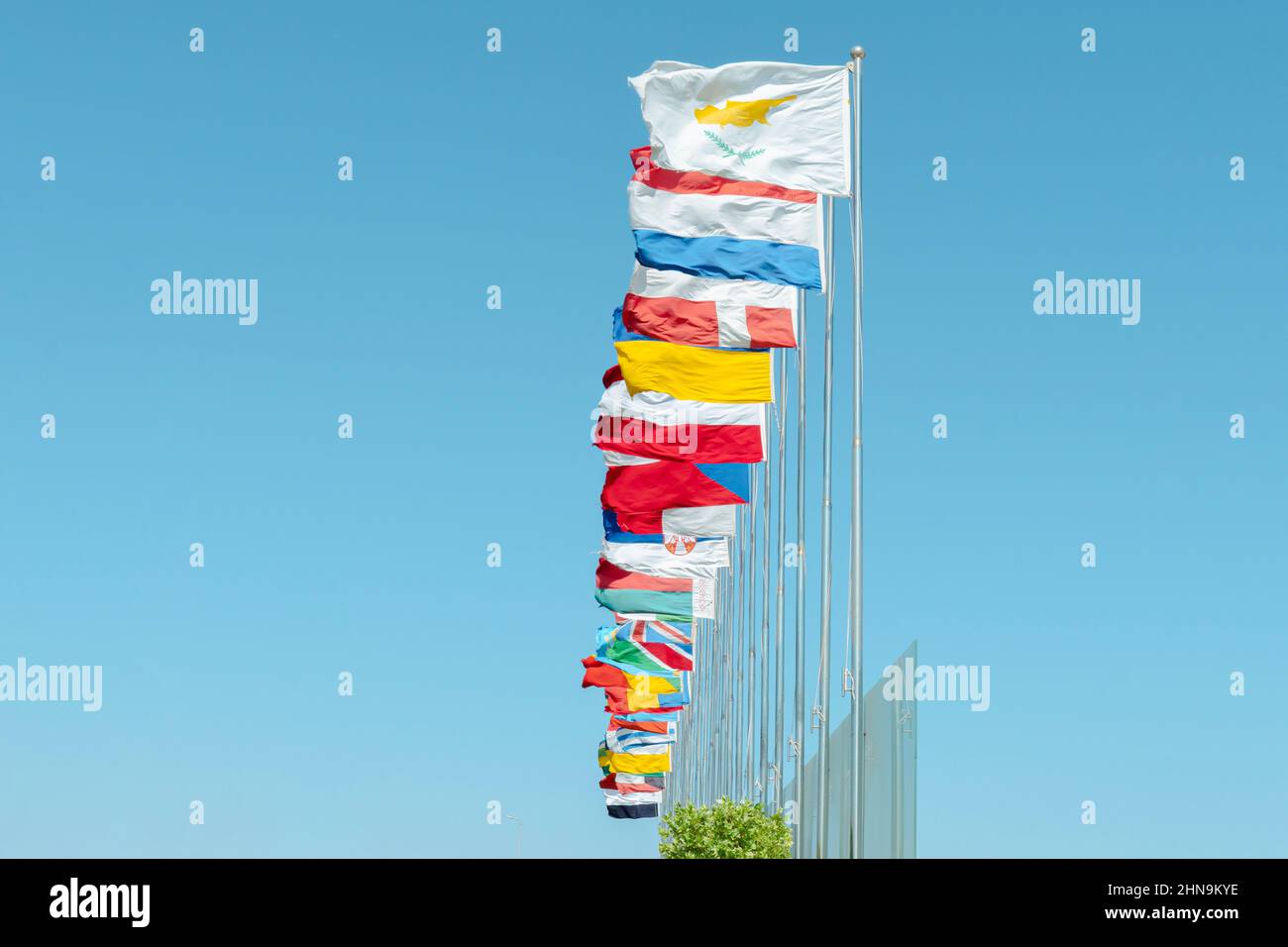 Vista ad angolo basso delle bandiere di vari membri delle Nazioni Unite che sbattono sul vento contro il cielo blu Foto Stock