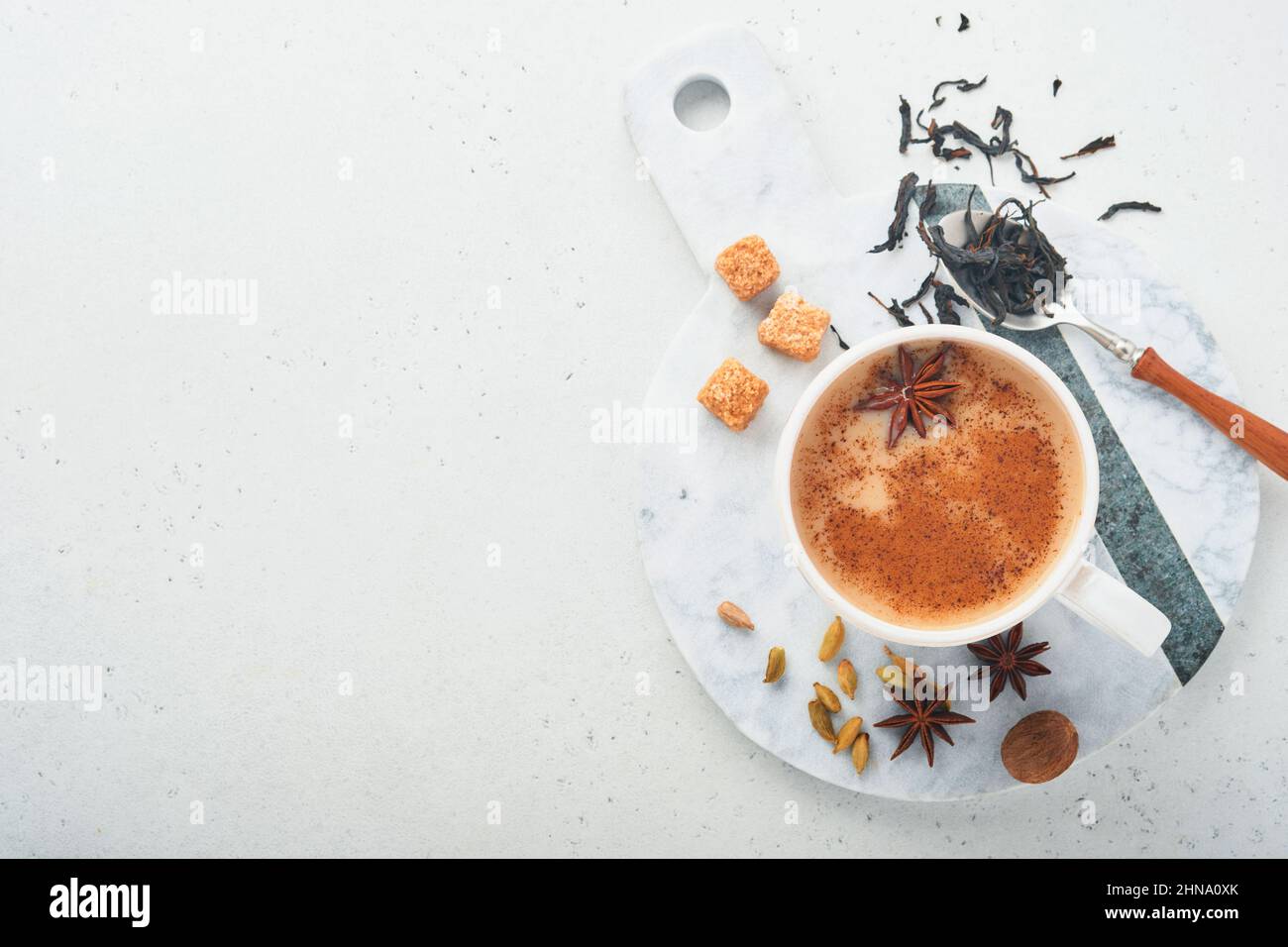 Tè Masala. Masala chai speziato tè con latte e spezie su sfondo grigio chiaro. Tradizionale bevanda indiana. Bevanda speziata. Spazio di copia. Vista dall'alto. Foto Stock