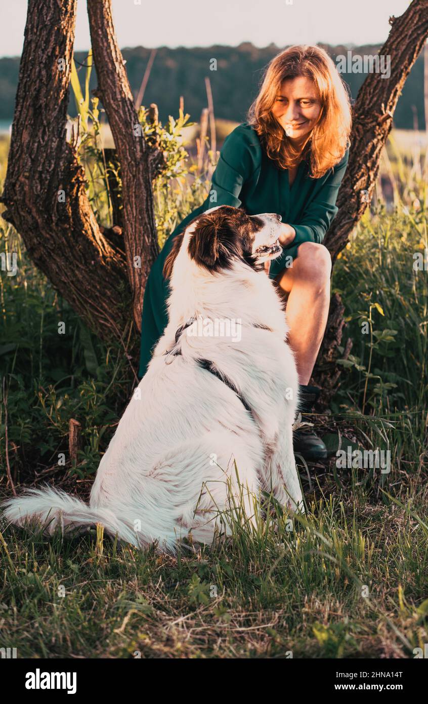 la giovane donna e il suo cane che si godono la natura all'aperto Foto Stock