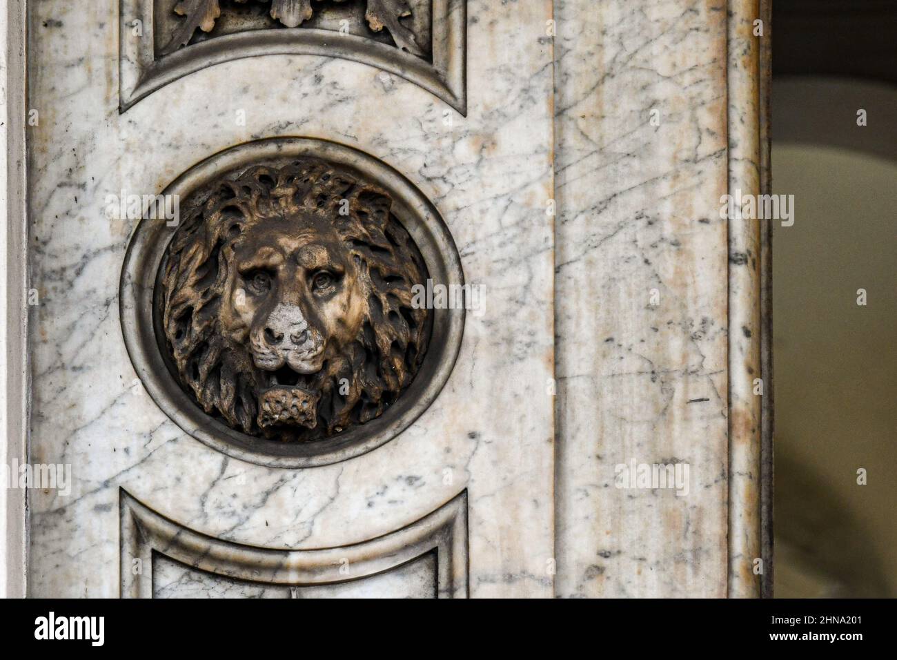 Primo piano di una porta con un bassorilievo in marmo raffigurante la testa di un leone, Torino, Piemonte, Italia Foto Stock