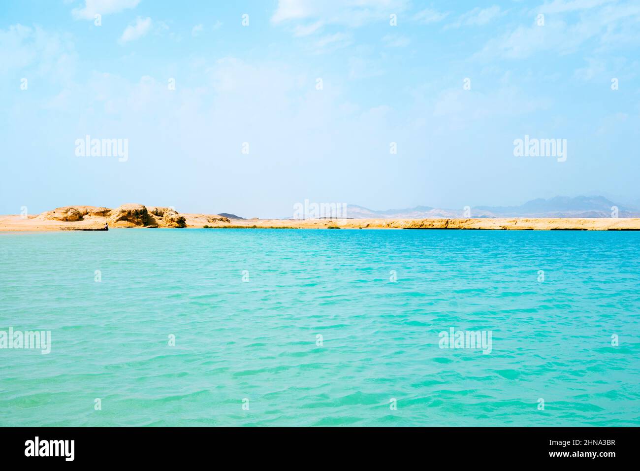Splendida vista sul mare di diversi colori, onde, costa sabbiosa, Egitto Mar Rosso, montagne. Acqua di mare blu verde turchese Foto Stock