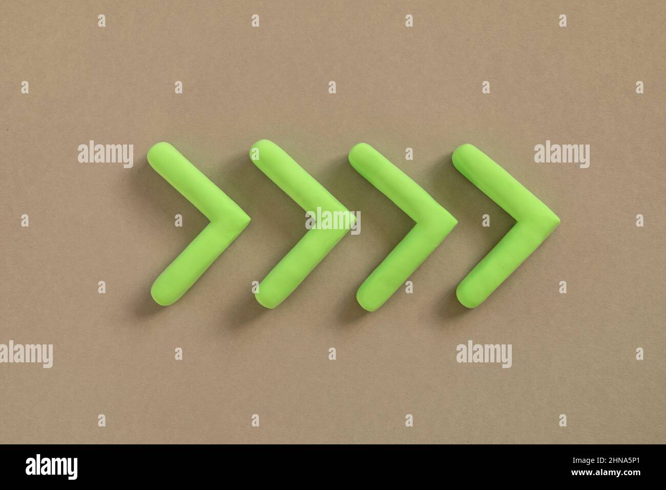 Frecce verdi che puntano a destra. Freccia tridimensionale che mostra la direzione su sfondo neutro. Concetto di sviluppo, andare verde o targ direzione Foto Stock