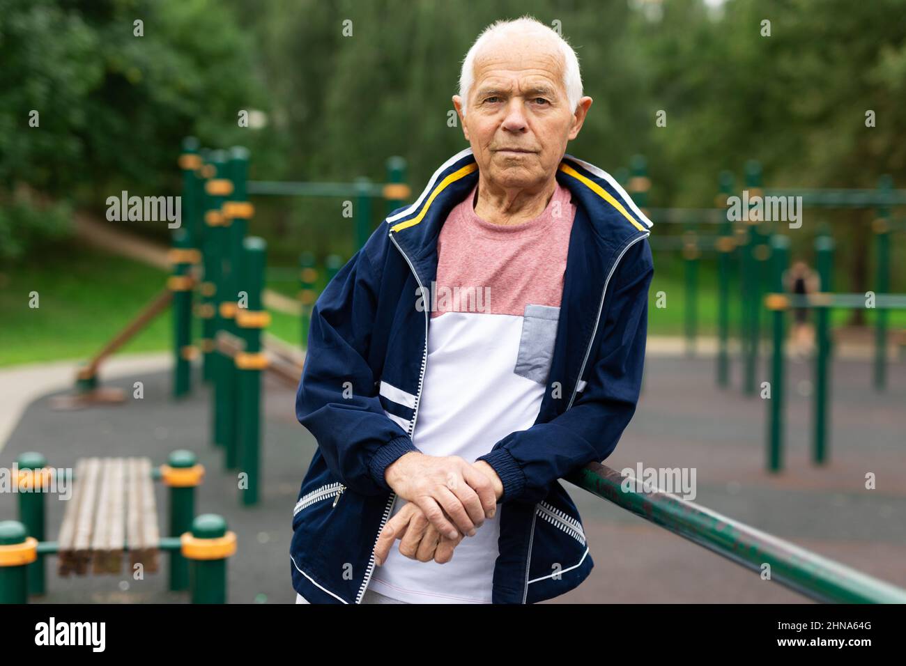 Ritratto di uomo anziano positivo in abbigliamento sportivo sul parco giochi Foto Stock