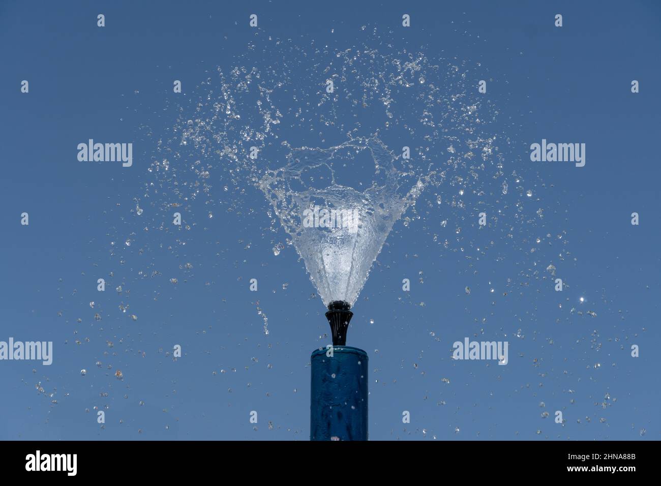 Una fontana blu spruzza acqua parco spruzzatori spruzzare acqua sopra per il divertimento estivo dei bambini. Foto Stock
