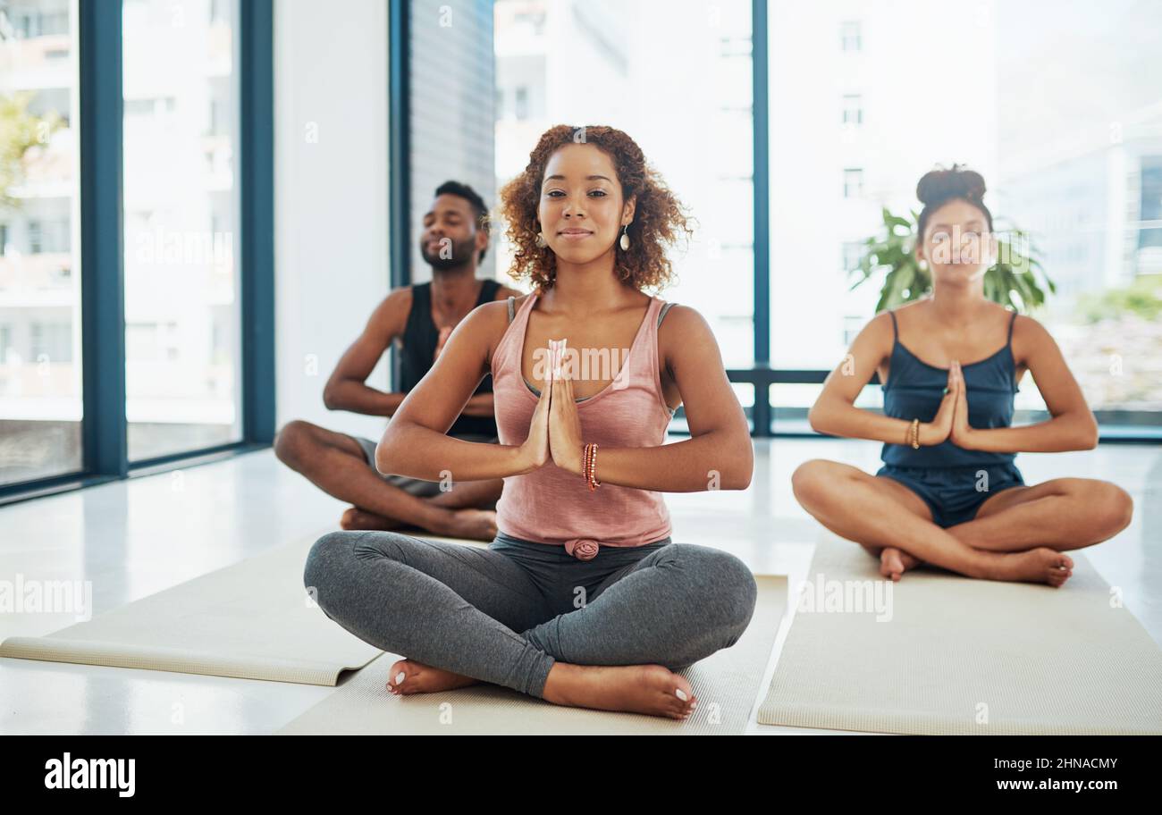 Si passa in un asana fino a quando non si sente il limite. Shot di un gruppo di persone che fanno yoga. Foto Stock