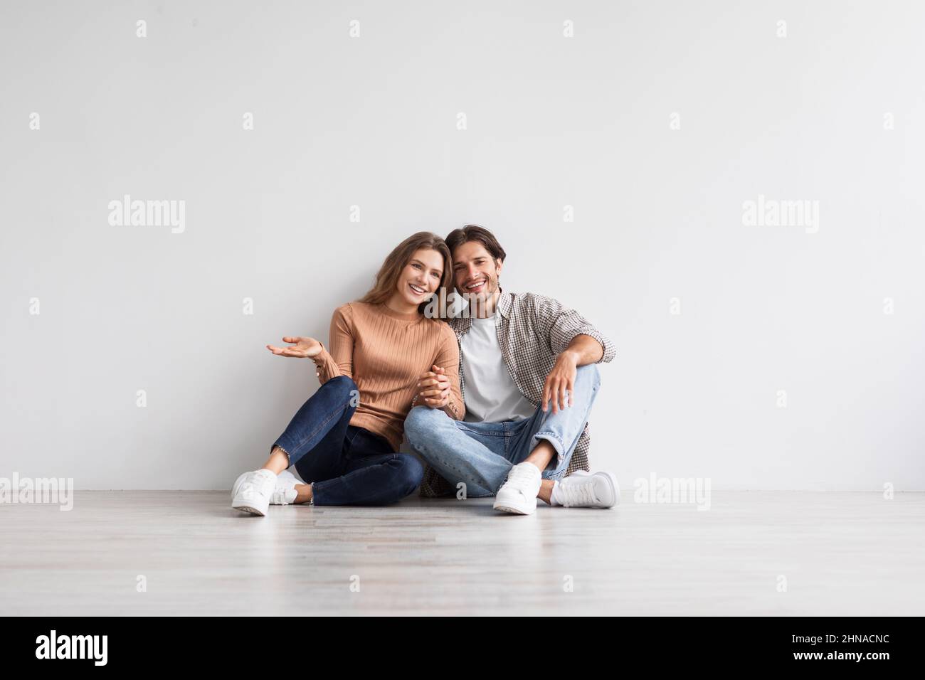 Sorridente giovane caucasico ragazzo e donna tiene le mani, progettando l'interno futuro della propria casa Foto Stock