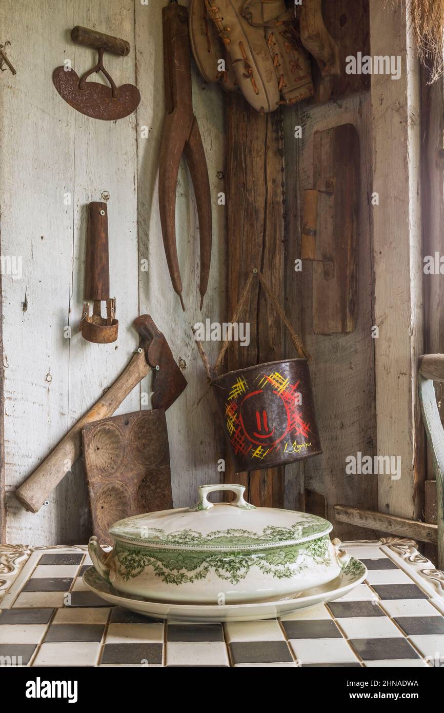 Piatto di porcellana antica con copertura sulla parte superiore della scacchiera e altri oggetti d'epoca all'interno di una vecchia cabina rustica in legno. Foto Stock