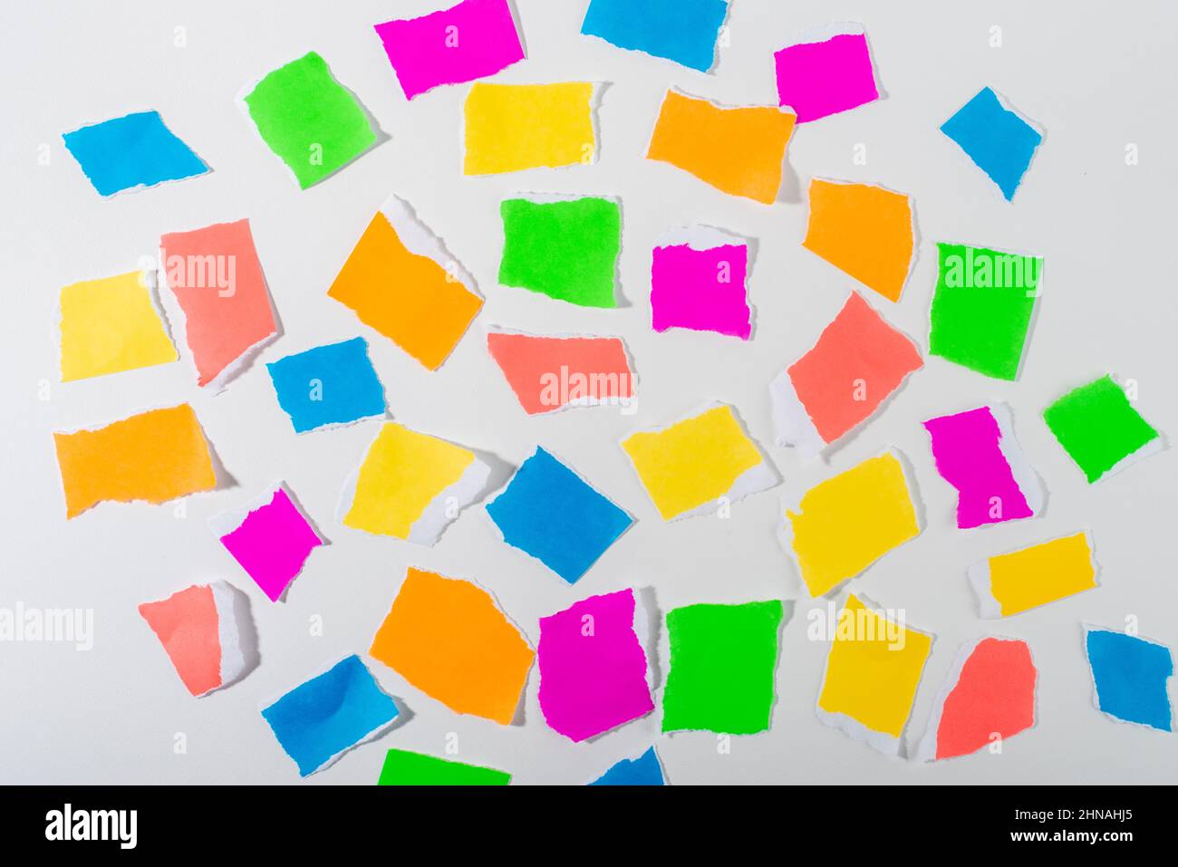 Pezzi di carta strappata di colore neon isolati su sfondo bianco. Foto Stock
