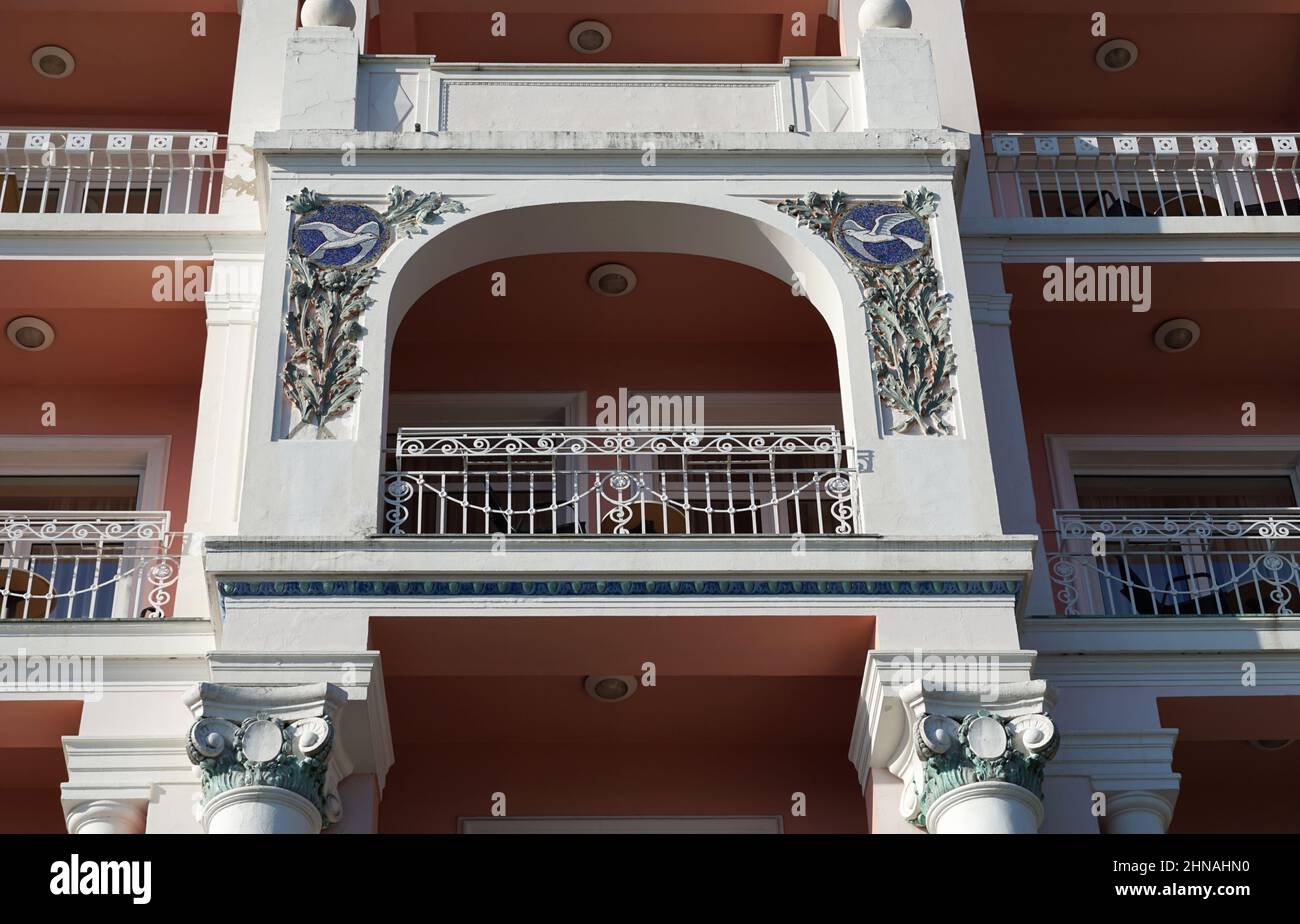 Opatija, Croazia, 22 gennaio 2022. Bellissimo romantico balcone bianco e arancione dell'edificio è decorato con decorazioni in muratura mosaico applicazione Foto Stock