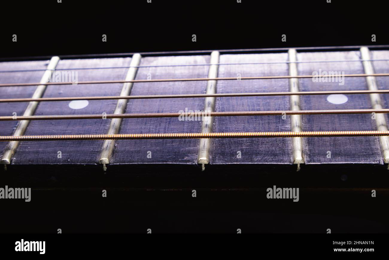 Dettagli del collo e della tastiera di una chitarra acustica. Foto Stock