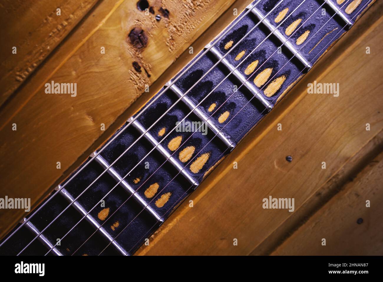 Primo piano di un collo e di una tastiera di una vecchia chitarra. Foto Stock