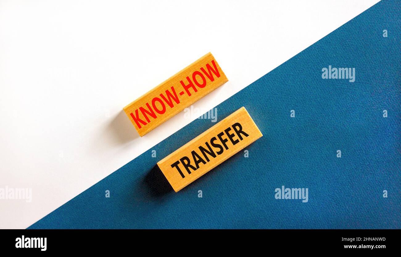 Simbolo di trasferimento del know-how. Concetto parole know-how trasferimento su blocchi di legno su bello sfondo bianco tabella blu. Spazio di copia. Innovazione aziendale A. Foto Stock