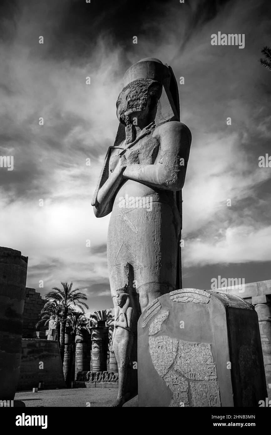 Colossale statua del re Ramesses II con sua figlia Bent'anta, al tempio di Karnak. Realizzato in granito rosso prima della seconda torre nella Corte Grande Foto Stock
