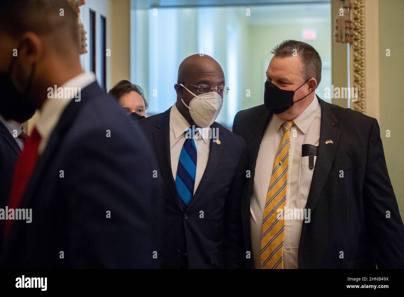 Il senatore degli Stati Uniti Raphael Warnock, un democratico della Georgia, e John Montana, un democratico del Montana, lasciano il pranzo del senato democratico caucus nella stanza di Mansfield al Campidoglio degli Stati Uniti a Washington, DC martedì 15 febbraio 2022. Credito: Bonnie Cash/CNP Foto Stock