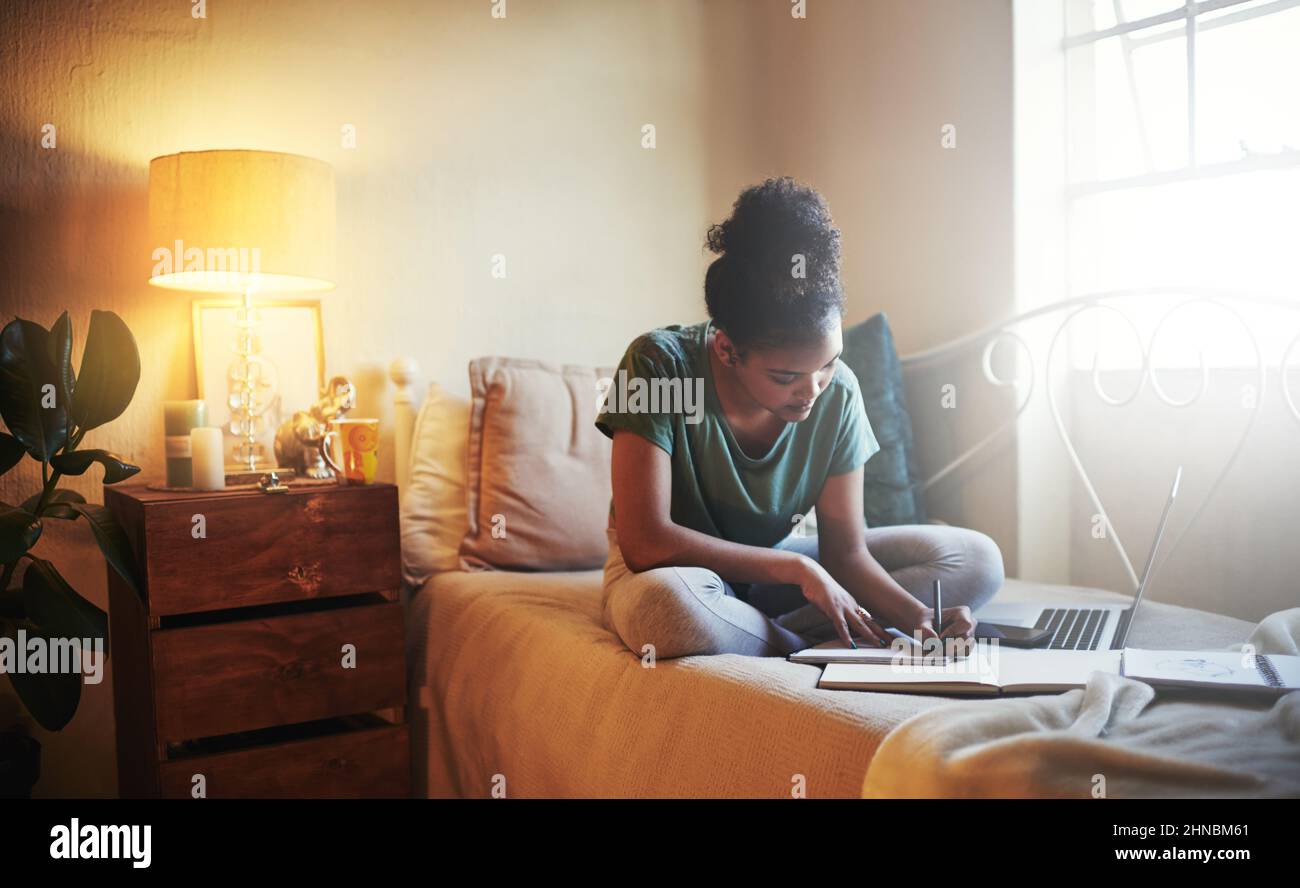 Shes uno studente diligente. Scatto a tutta lunghezza di una giovane studentessa studentessa che studia a casa. Foto Stock