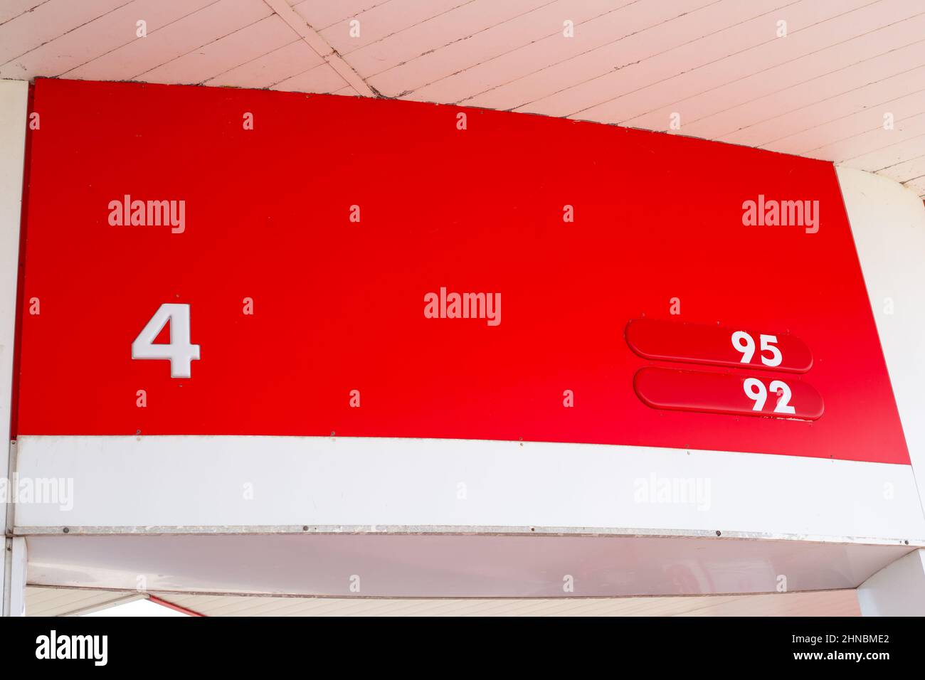 Stazione di servizio auto con indicatore a colonna e numero di carburante su sfondo rosso. Settore petrolifero. Foto Stock