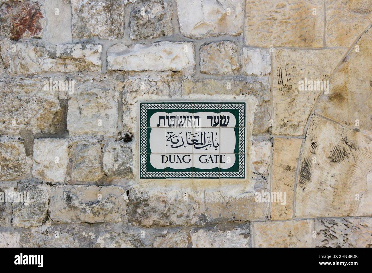 Un cartello stradale trilingue, in ebraico, arabo e inglese, che designa la porta Dung, AKA: Porta Silwan o porta Mughrabi, alle mura della città vecchia di Gerusalemme. Foto Stock