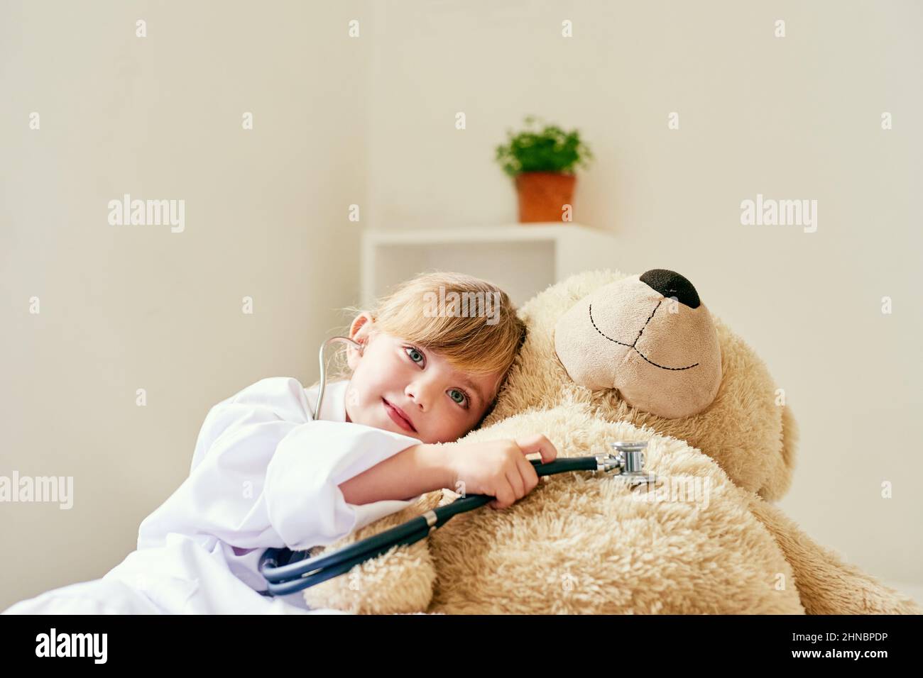 Ora thats un cuore felice che suona. Girato di una bambina adorabile vestita come medico ed esaminando un orsacchiotto con uno stetoscopio. Foto Stock