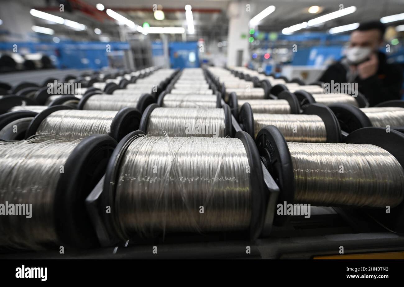 Stoccarda, Germania. 15th Feb 2022. Un operatore posiziona le bobine di filo su uno scaffale per la lavorazione in cavi speciali in un locale di produzione presso il produttore di cavi Lapp Kabel. Il produttore mondiale di cavi annuncerà i dati relativi all'ultimo anno fiscale nel corso di una conferenza stampa online il 16 febbraio. Credit: Bernd Weißbrod/dpa/Alamy Live News Foto Stock