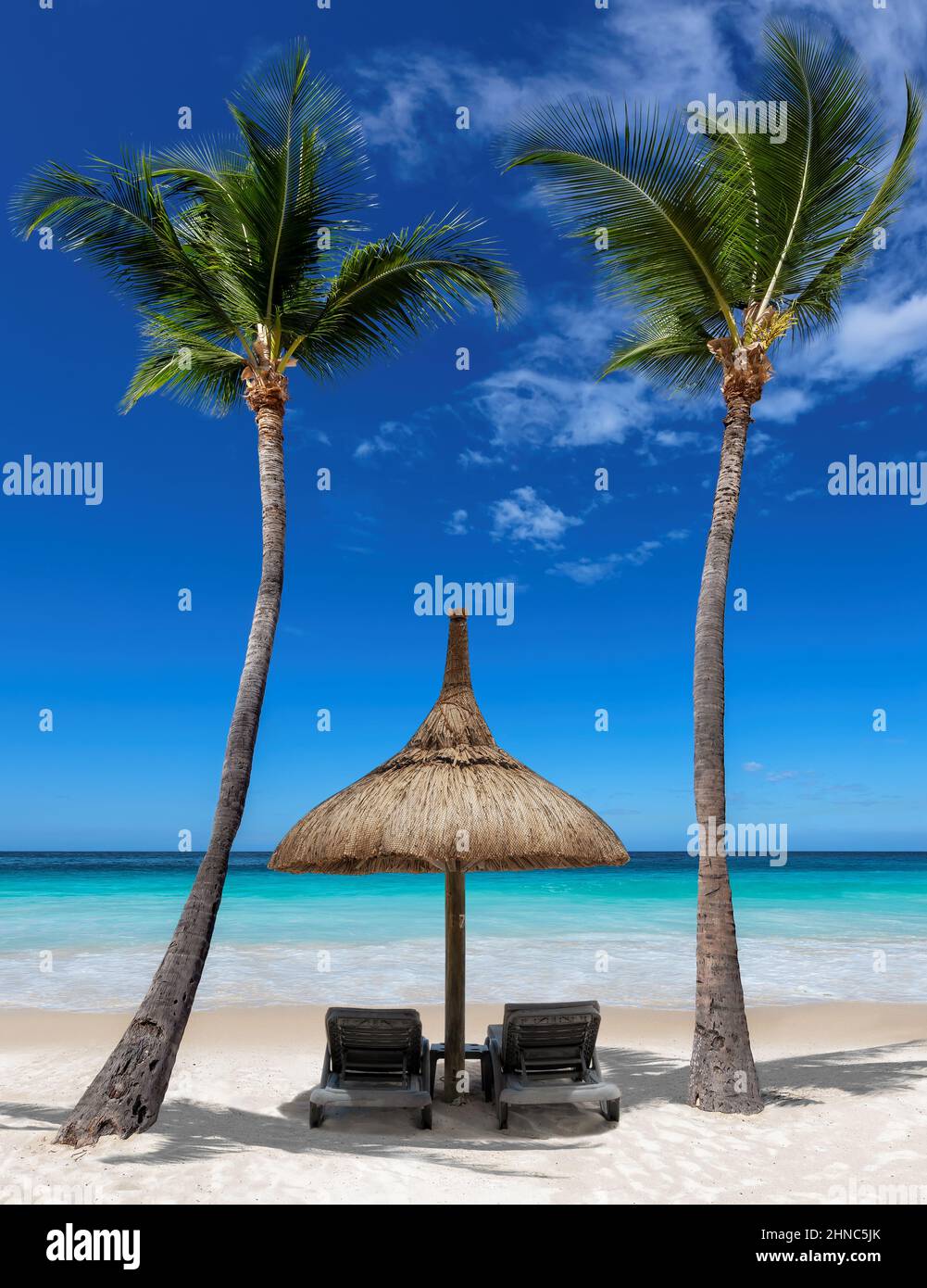 Sedie e ombrello in soleggiata spiaggia tropicale di Palm e mare turchese. Foto Stock