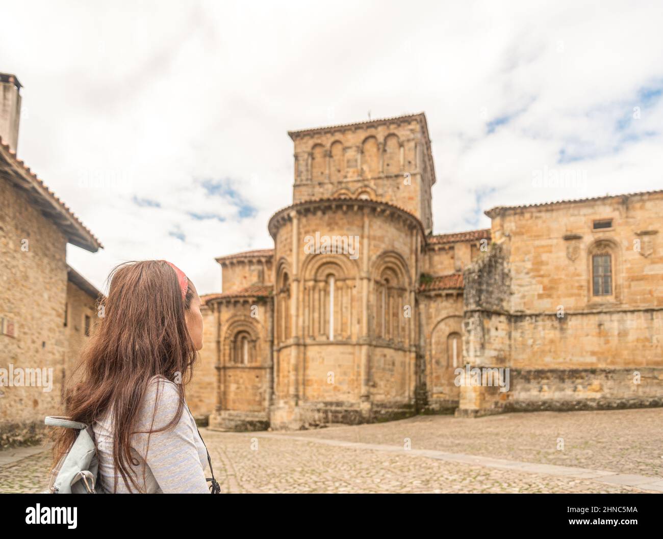 Donna anonima che visita antica chiesa cattolica in pietra Foto Stock