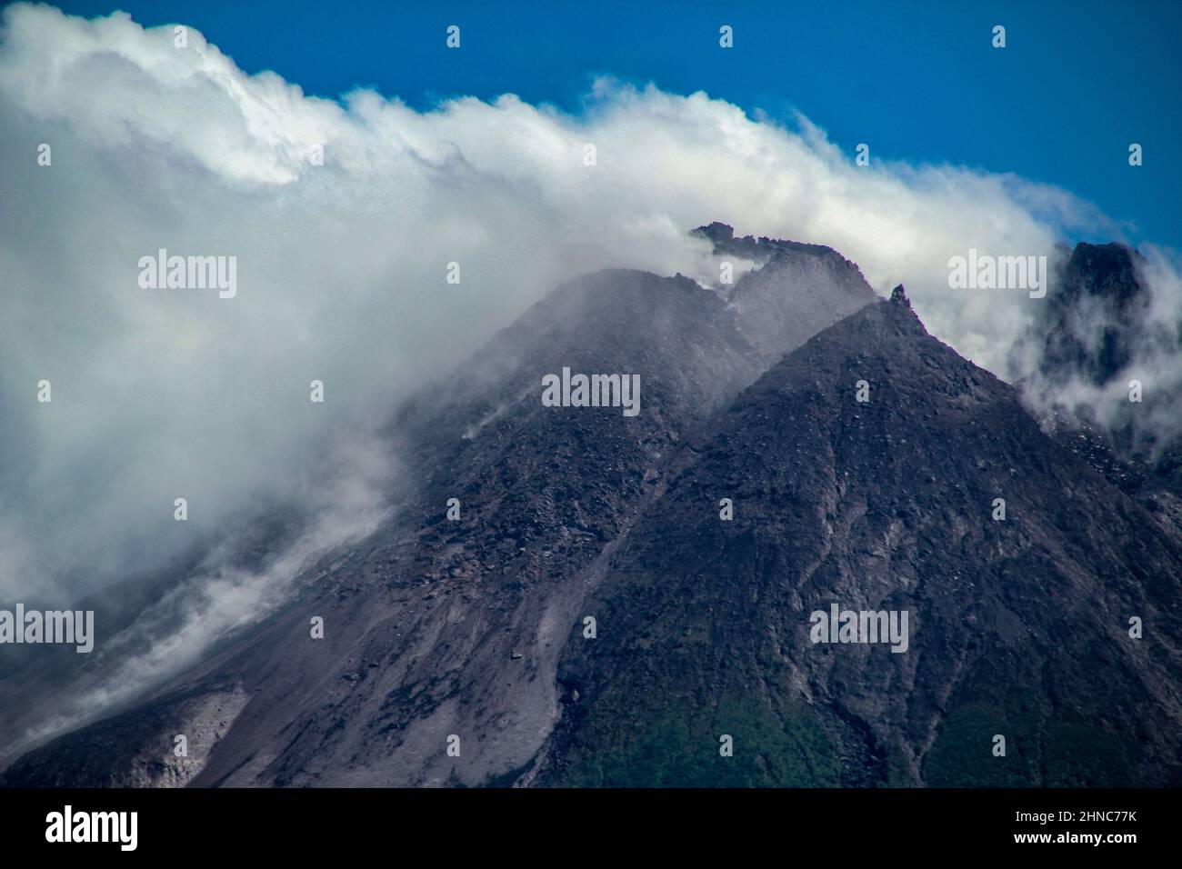 Sleman, Yogyakarta, Indonesia. 16th Feb 2022. La vetta del Monte Merapi con la sua cupola è visibile a Sleman, Yogyakarta, Indonesia, mercoledì 16 febbraio 2022. Il volume della cupola lavica sudoccidentale è di 1.670.000 m3 e la cupola centrale è di 3.007.000 m3. Il monte Merapi è al livello di allerta con l'attuale potenziale pericolo sotto forma di valanghe laviche e nuvole calde nel settore sud-sud-occidentale che copre il fiume Boyong per un massimo di 5 km, il fiume Bedog, Krasak, Bebeng per un massimo di 7 km. Il settore sud-est copre il fiume Woro per un massimo di 3 km e il fiume Gendol per un massimo di Foto Stock