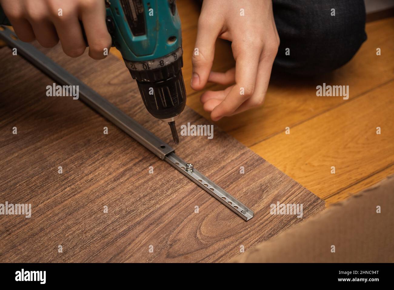 Cacciavite a mano maschio avvitando le viti per attaccare il dettaglio ruba parte a scheda. Montaggio di mobili a casa. Spazio di copia. Utilizzo Foto Stock
