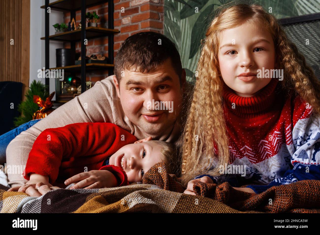 Daddy figlio e figlia sdraiati sul letto. Foto Stock