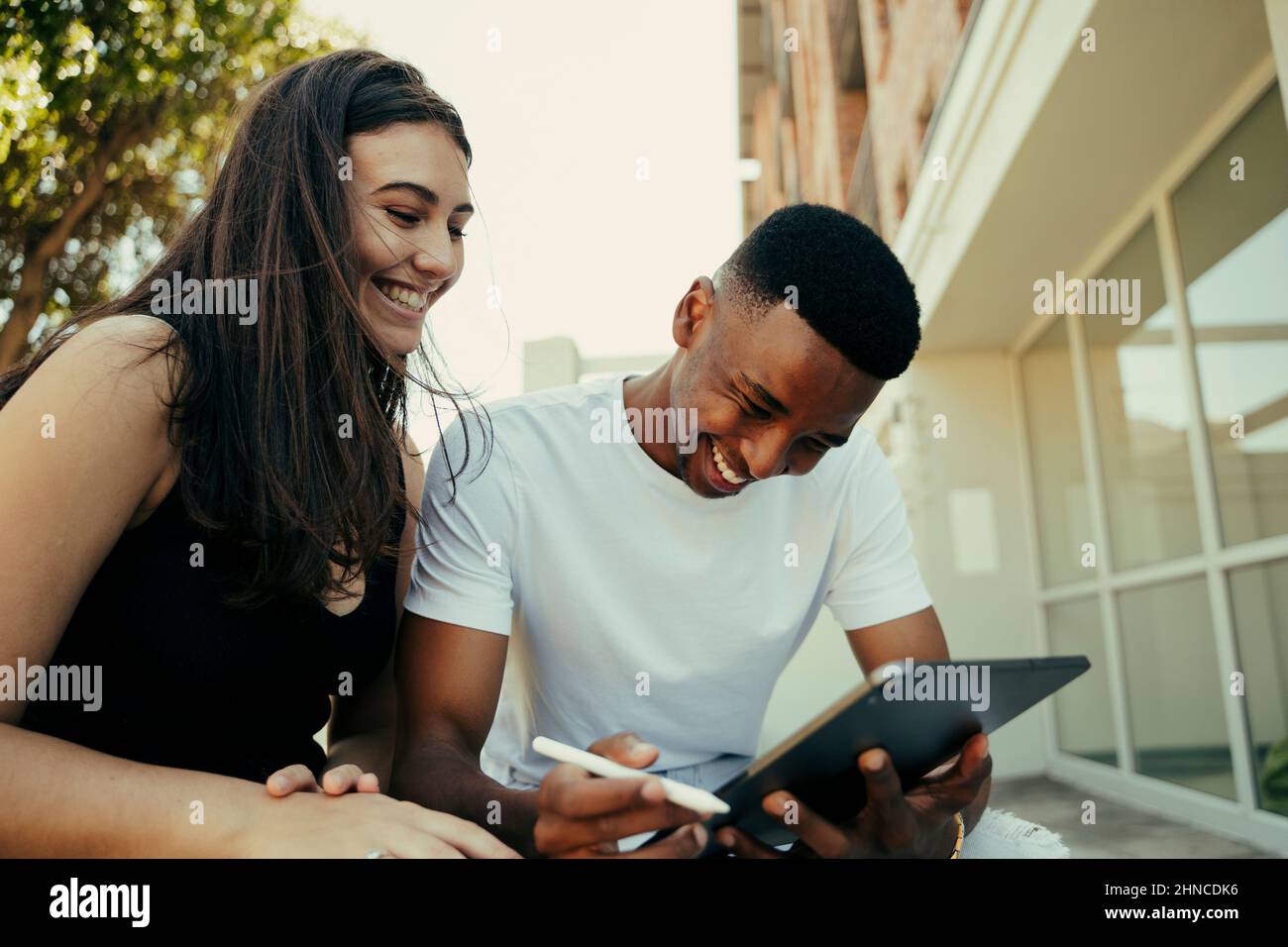 Coppia romantica biraciale ridere mentre scorre su tablet digitale Foto Stock