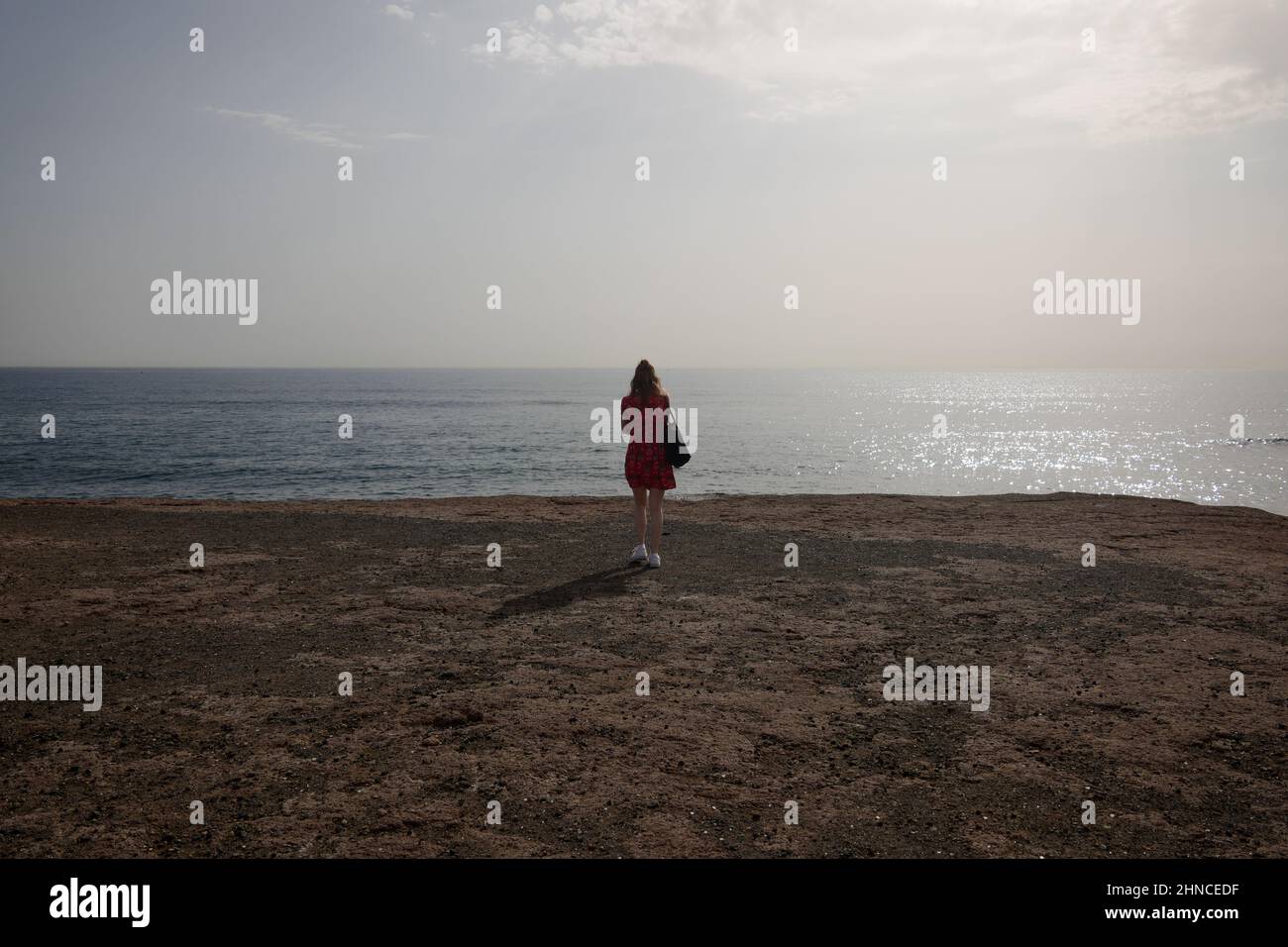 Una giovane donna di fronte al mare, El Médano, Tenerife sud, Isole Canarie, Spagna, Febbraio 2022 Foto Stock