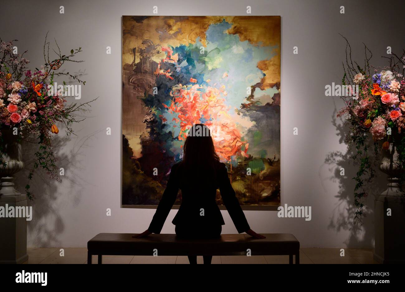 Christie’s, Londra, Regno Unito. 16 febbraio 2022. Un momento clou contemporaneo nel 20th/21st secolo: London Evening sale il 1 marzo 2022 a Christie’s is Flora Yukhnovich’s Tu vas me faire rougir (you've going to make me blush), 2017, stima £250.000-350.000, posato con il membro del personale della galleria. Il dipinto si ispira al capolavoro rococò di Fragonard del 18th secolo, The Swing. Credit: Malcolm Park/Alamy Live News. Foto Stock