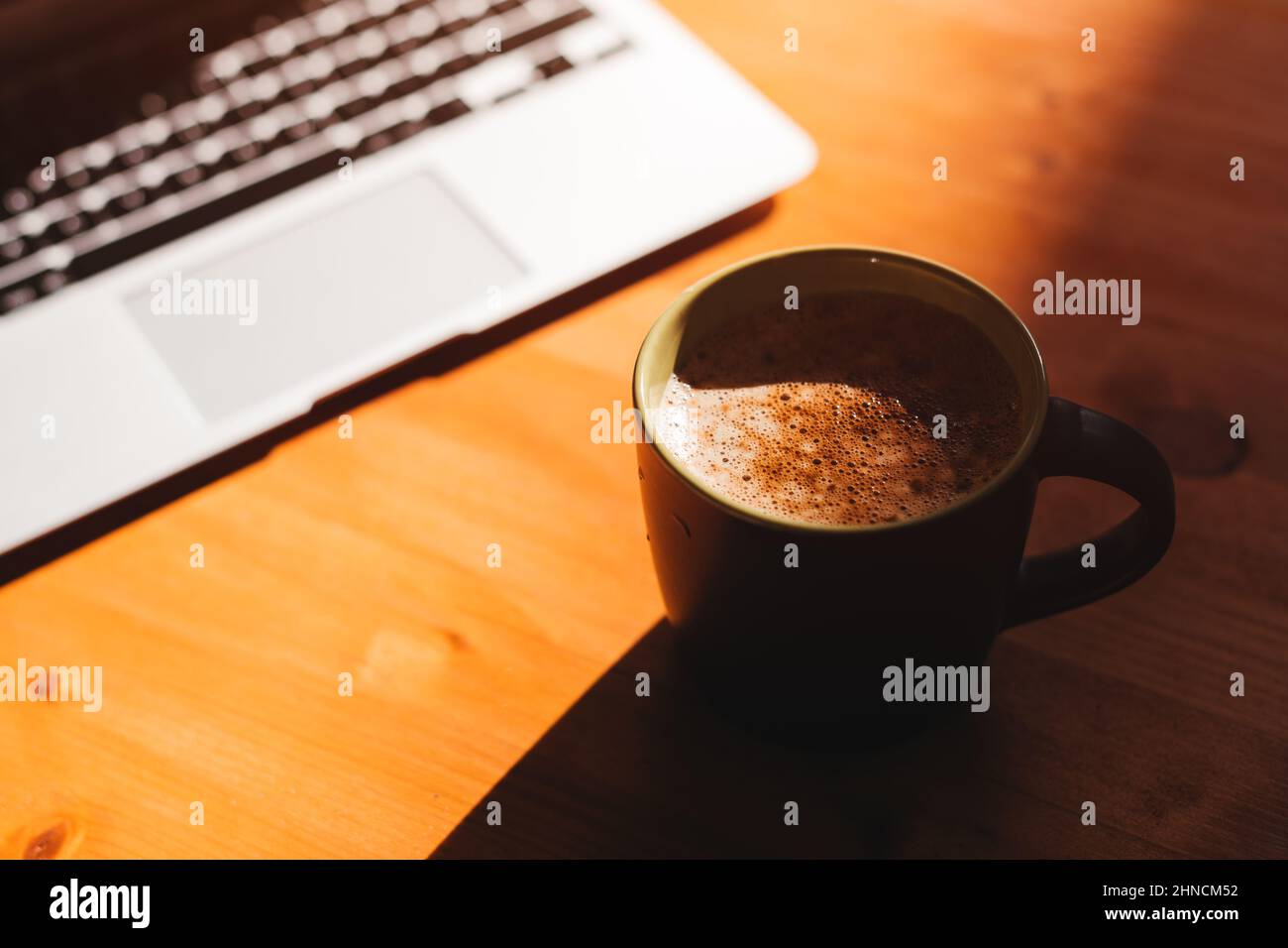 Pausa caffè in ufficio, computer portatile e tazza di caffè sulla scrivania, focus selettivo Foto Stock