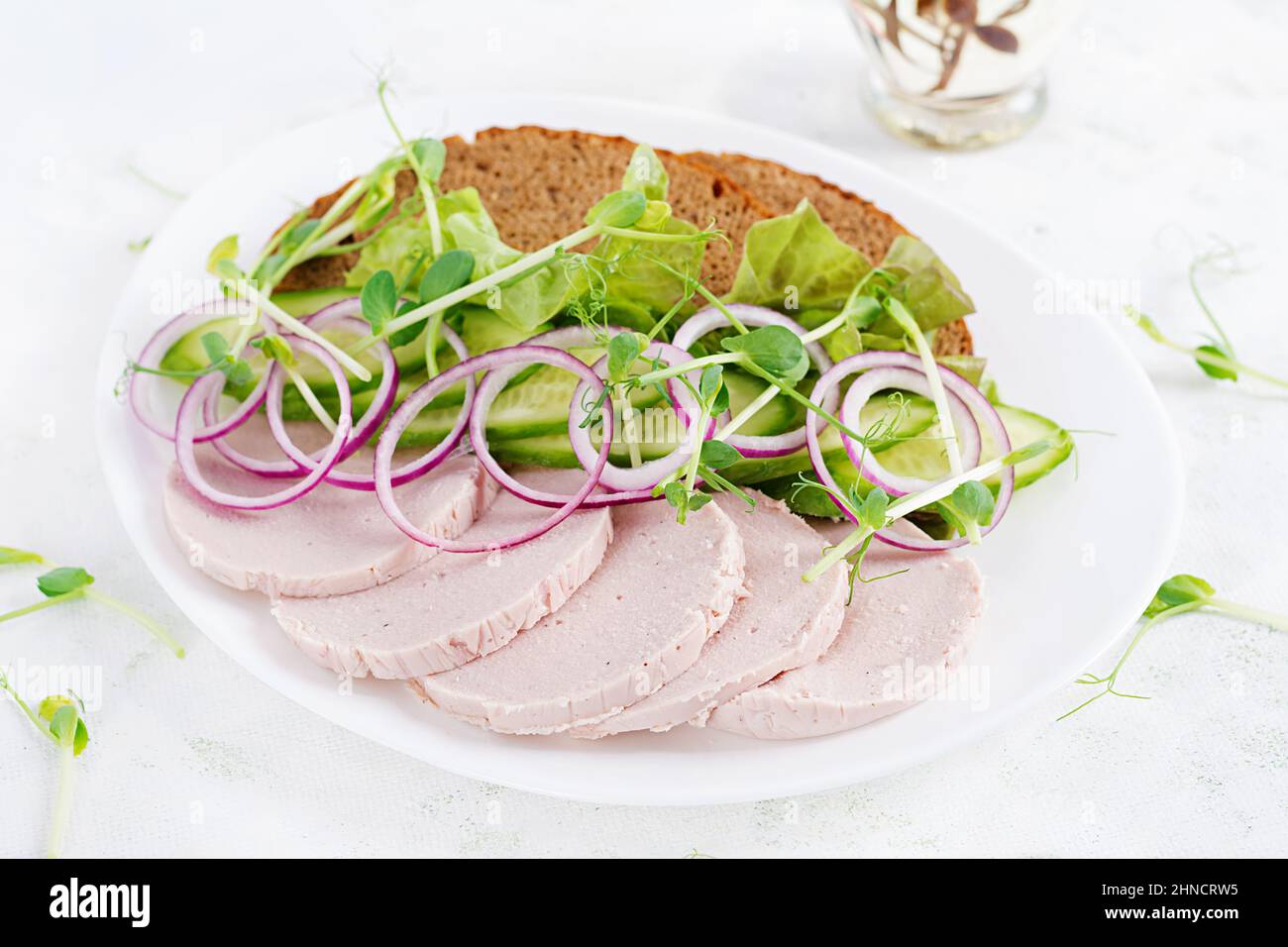Sandwich con salsiccia di pollo fatta in casa, lattuga e cetriolo nel piatto Foto Stock