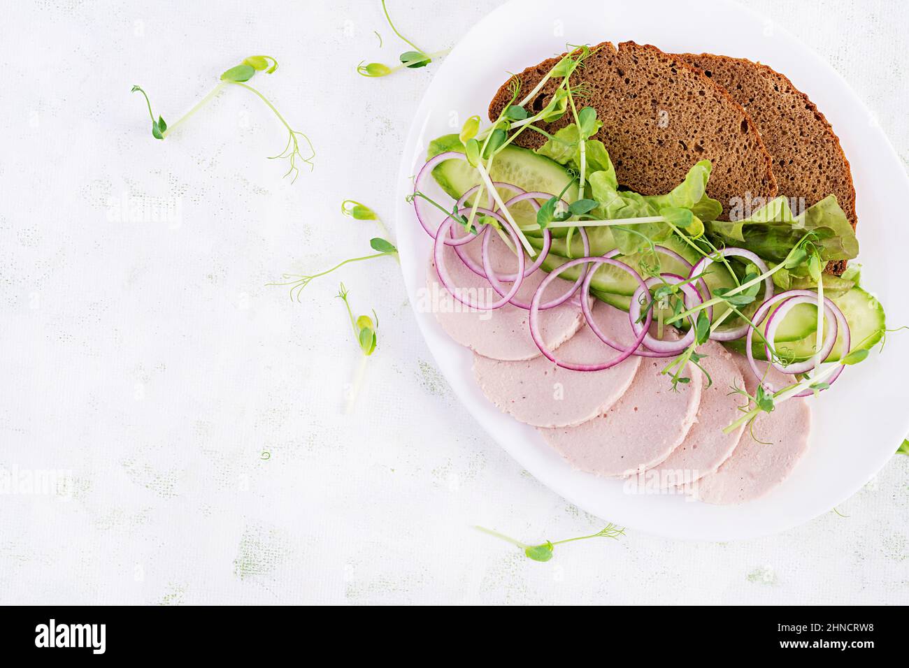 Sandwich con salsiccia di pollo fatta in casa, lattuga e cetriolo nel piatto. Vista dall'alto, sopra Foto Stock