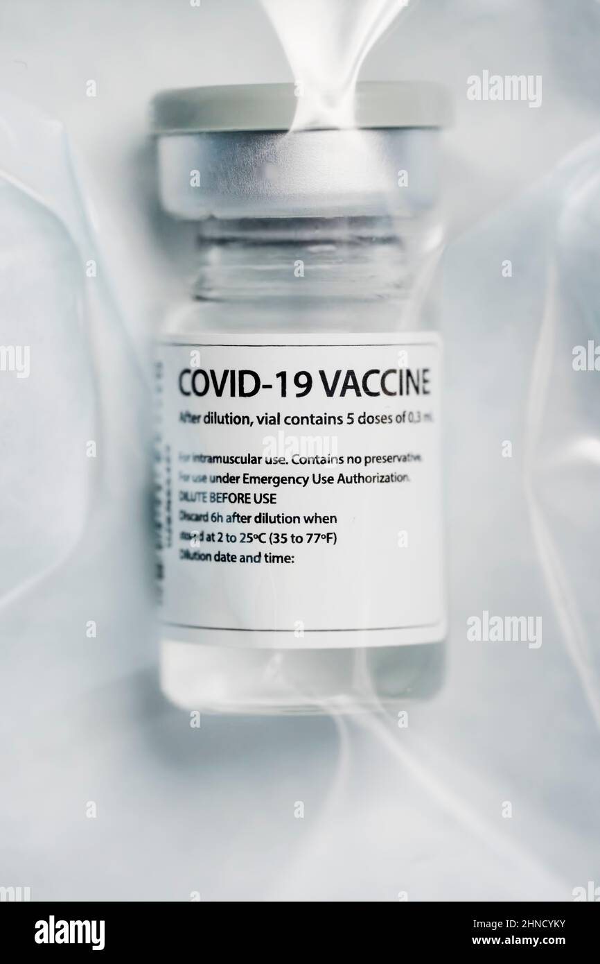 Flaconcino di vetro medico di richiamo del vaccino del coronavirus sigillato su un sacchetto di plastica Foto Stock