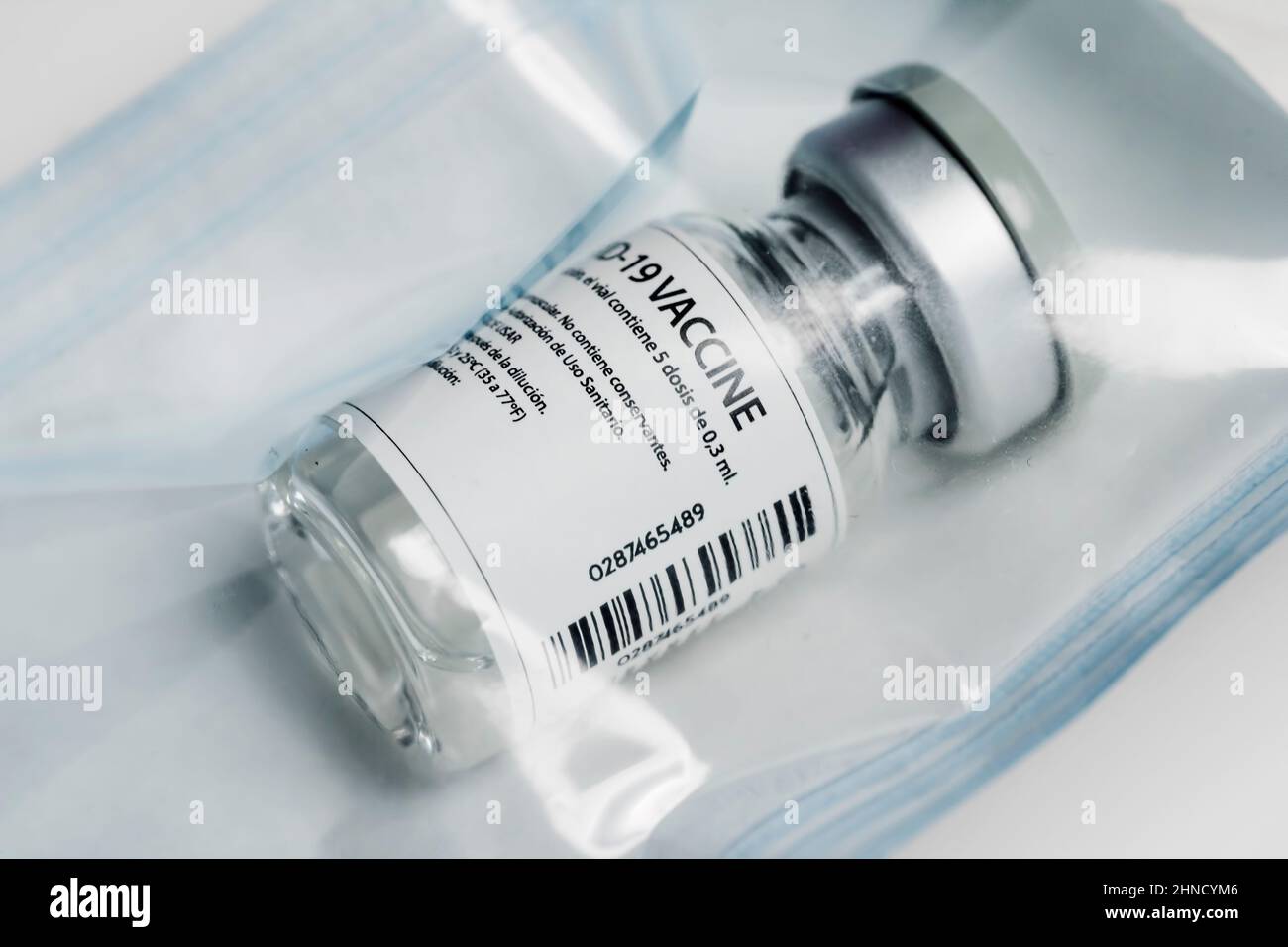 Flaconcino di vetro medico di richiamo del vaccino del coronavirus sigillato su un sacchetto di plastica Foto Stock