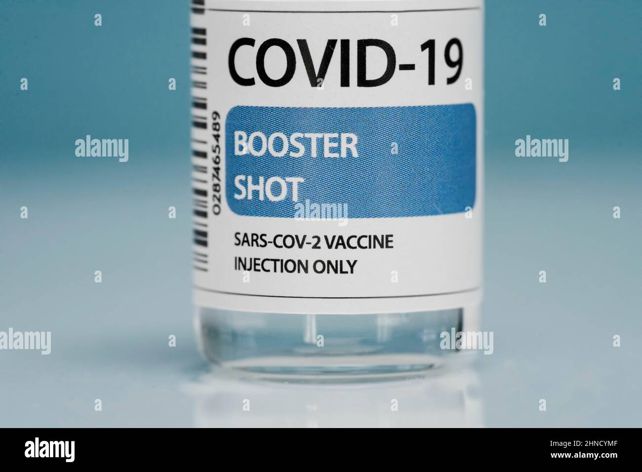 Flaconcino di vetro di richiamo medico con vaccino contro il coronavirus posto su sfondo blu Foto Stock