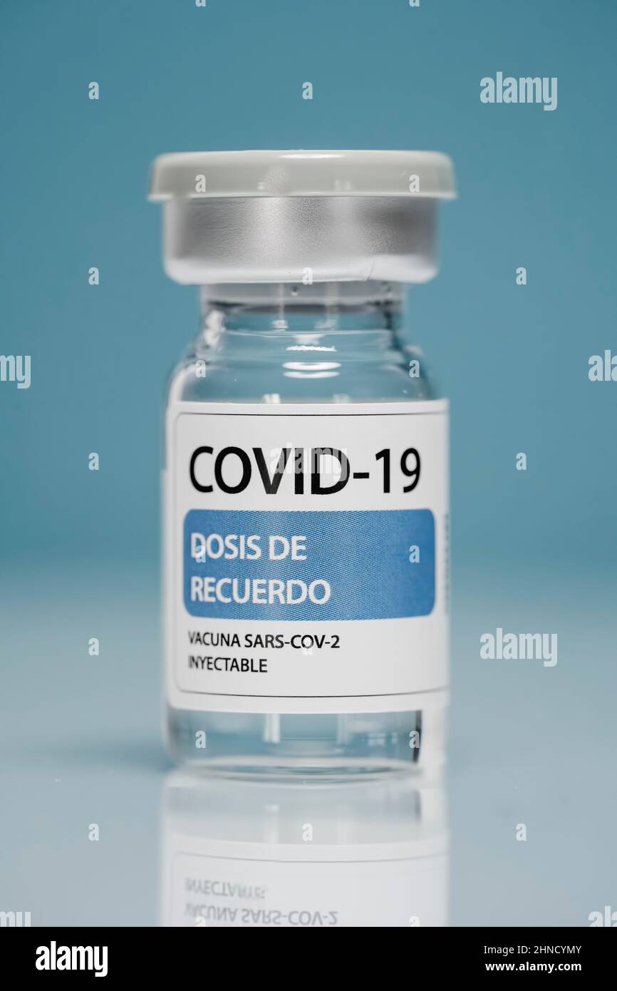 Flaconcino di vetro di richiamo medico con vaccino contro il coronavirus posto su sfondo blu Foto Stock