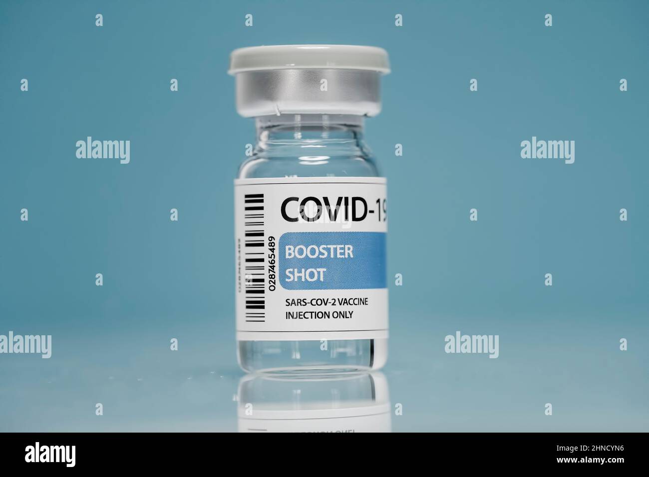 Flaconcino di vetro di richiamo medico con vaccino contro il coronavirus posto su sfondo blu Foto Stock