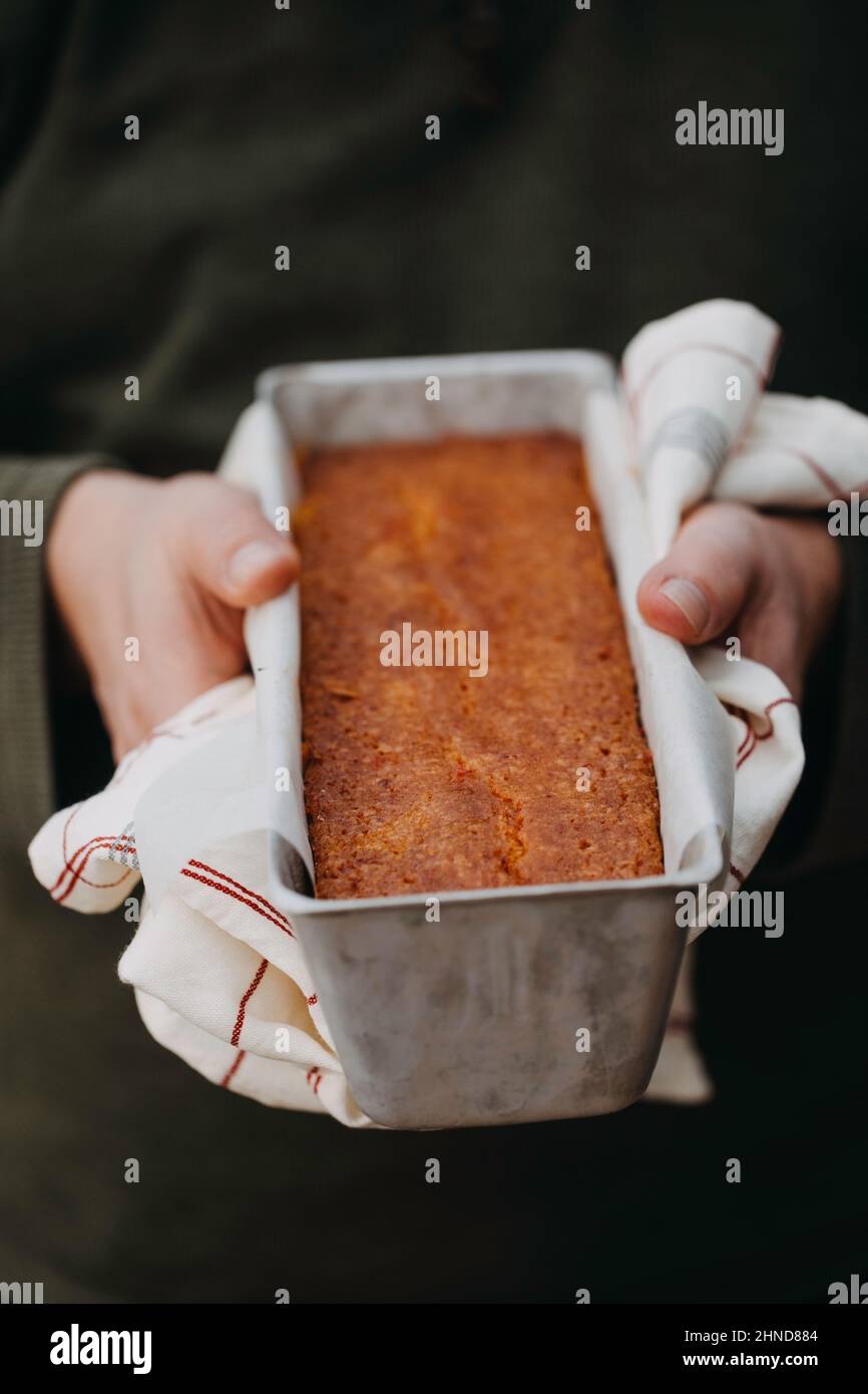 Mani dell'uomo che tengono una barattina di torta d'arancia del sangue Foto Stock