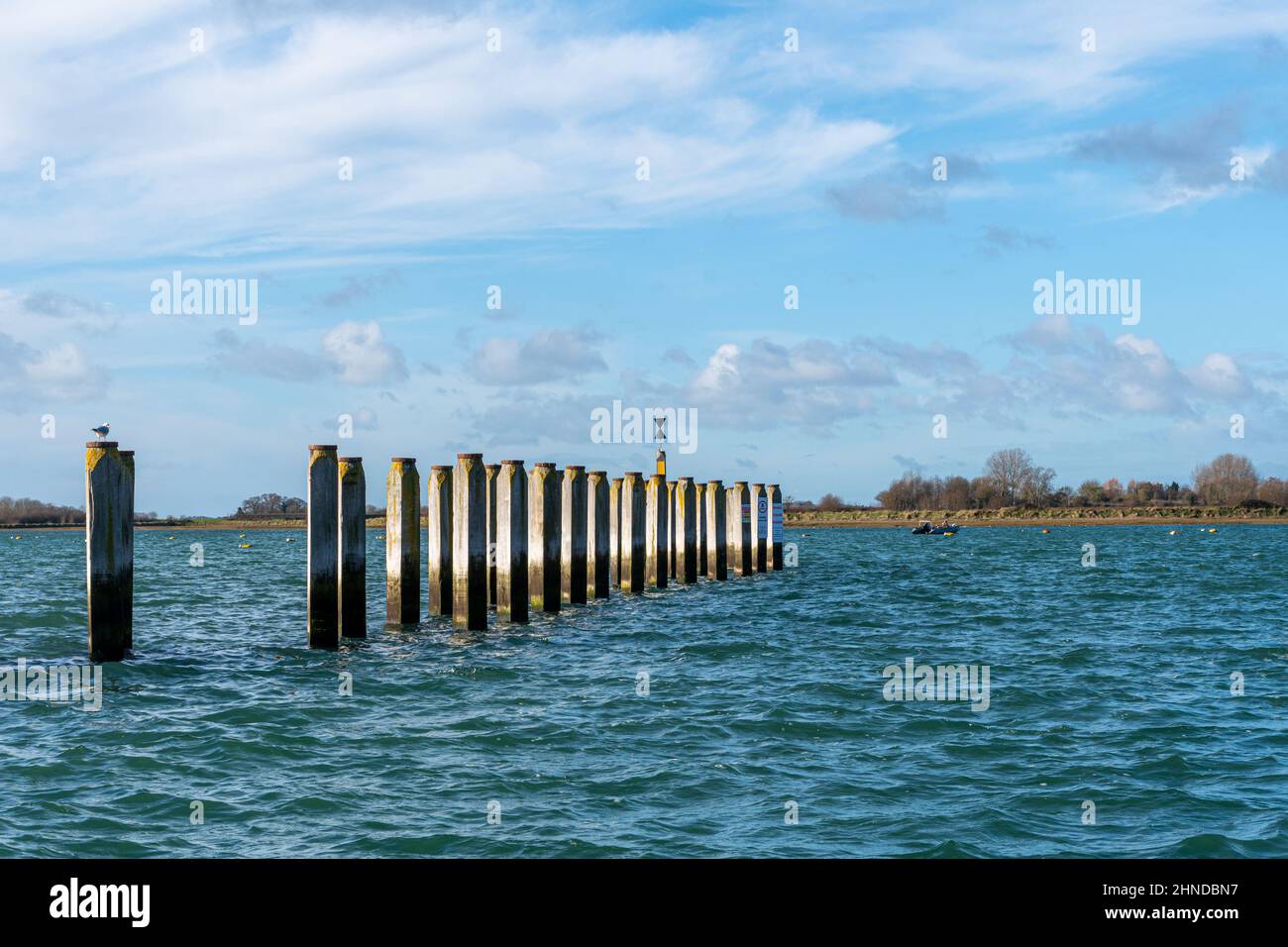 Pali di legno che marchiano il canale di nautica al porto di Bosham nel Sussex occidentale, Inghilterra, Regno Unito Foto Stock