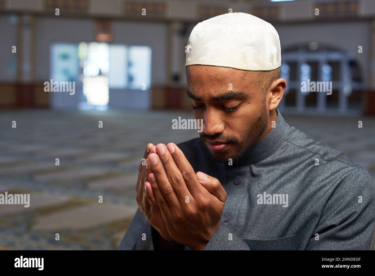 Ritratto di un giovane musulmano che fa dua e prega in una moschea Foto Stock